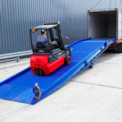 the red forklift driving up on the blue loading ramp into the empty container, easyramps.co.uk - heavy-duty loading ramps uk