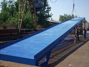 the crane is lifting up blue ramp for the cars, order bespoke mobile loading ramps